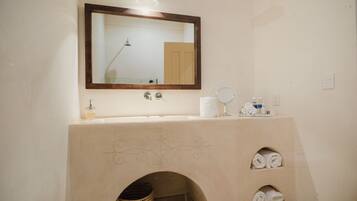 Een douche, designer toiletartikelen, een haardroger, badjassen