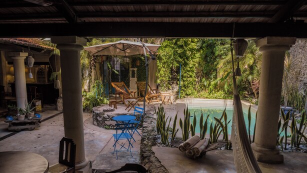 A covered outdoor area with a pool, seating, and plants. - Los Murmullos Casa Boutique Campeche (Campeche)