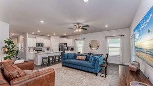 A modern living room with a blue sofa, a brown leather couch, and a wooden coffee table. - WindMark | Golf Cart | Pet Friendly | In-Law Suite (Port St Joe)