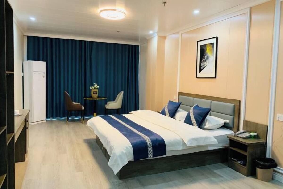 Une chambre d’hôtel avec un grand lit, un bureau et une chaise.