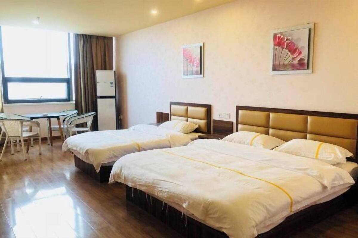 Une chambre d’hôtel avec deux lits, un bureau et une chaise.