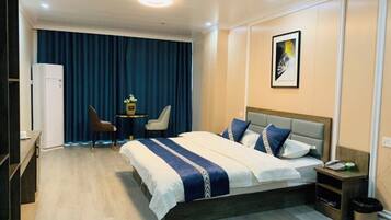 Een hotelkamer met een bed, nachtkastje, stoel en een bureau met stoel.