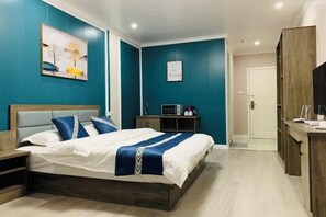 Een slaapkamer met een bed, nachtkastje en bureau met stoel.