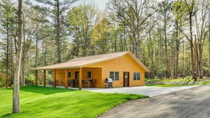 A log cabin with a porch, a grill, and a paved driveway. - Near Memorial Park: Lake Arbutus Vacation Rental (Hatfield)