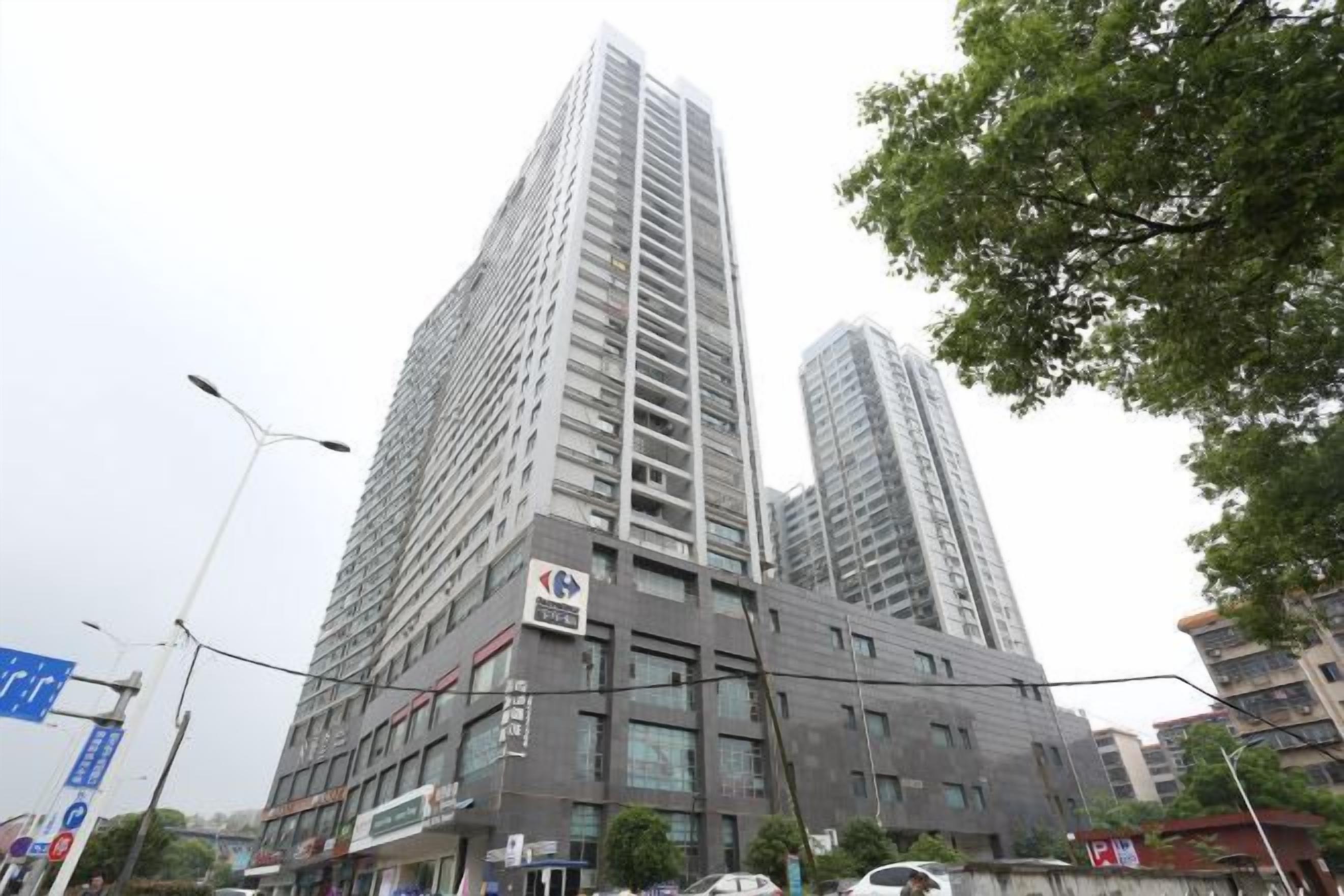 A high-rise building with multiple floors, large windows, and a commercial ground floor.