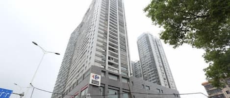 Un immeuble de grande hauteur, doté de nombreux étages, de grandes fenêtres et d’un rez-de-chaussée à vocation commerciale.
