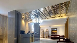 A reception area with a desk, chairs, and a decorative ceiling. - Yading Paradise Inn (Daocheng County)