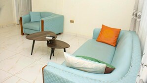 Un salon avec un canapé bleu clair, un fauteuil assorti et une petite table basse.