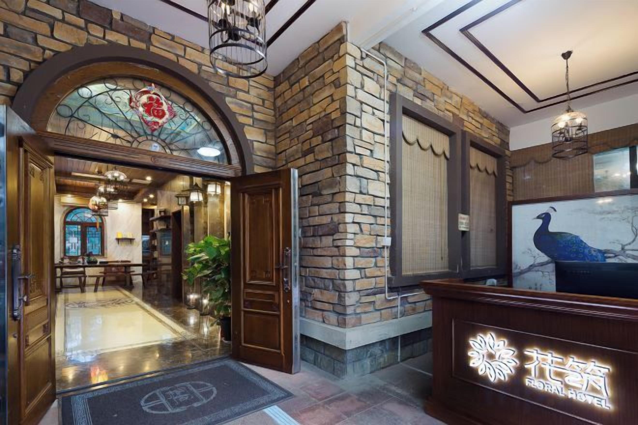 Vestíbulo de hotel con mostrador de recepción, una escalera y un ventanal con vistas.