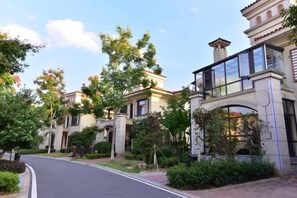 A residential street with houses featuring balconies, a paved road, and lush greenery. - Ningxiang Shande Hall Inn (Ningxiang)