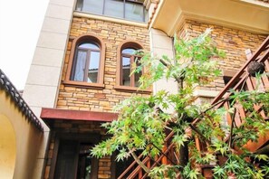 A building with a brick facade, two arched windows, and a staircase.