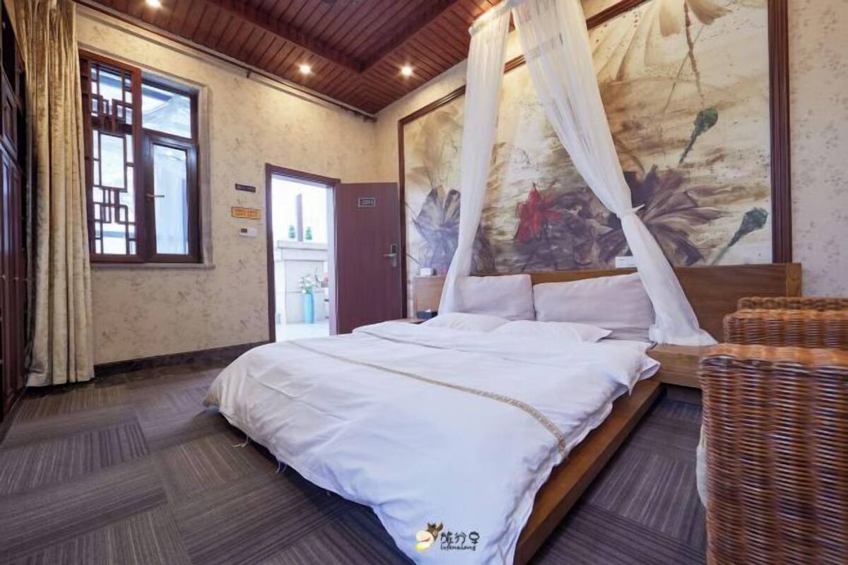 Une chambre à coucher avec un lit, un baldaquin, un tableau et une porte.