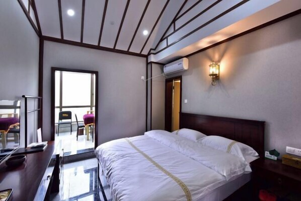 A hotel room with a bed, a desk, a chair, and a window. - Ningxiang Shande Hall Inn (Ningxiang)