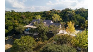 Una casa circondata da alberi fitti e un cielo sereno.