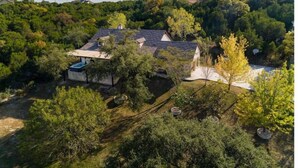 A house surrounded by dense trees and a clear sky. - Outdoor Living at Its Finest - Group Spa, Fire Gathering, Star Dining (Jonestown)
