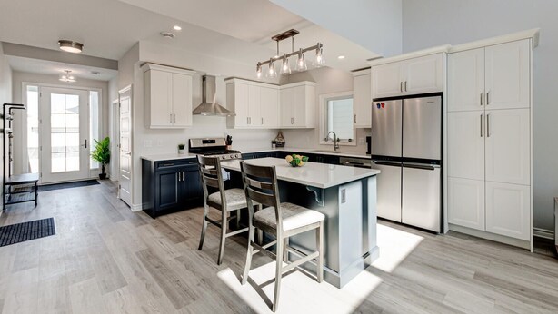 A modern kitchen with white cabinetry, a central island, and stainless steel appliances. - Cozy, spacious family home w/ Arcade! 5 mins from Beach! (Port Stanley)