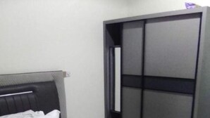 Une chambre à coucher avec un lit, une tête de lit et une armoire.