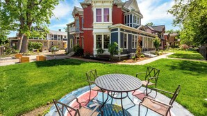 A two-story house with a large front yard, a patio with a round table and chairs, and a well-maintained lawn. - Boise-Historical-Northend-Downtown-Franklin 101 (Boise)