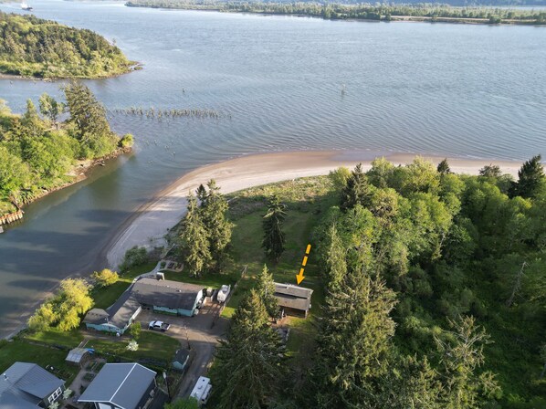 A lakeside property with a dock, a small boat, and a beach area.