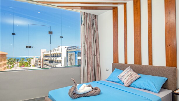 A hotel room with a bed, a view of the city, and a balcony. - Bedcoin Hostel (Hurghada)