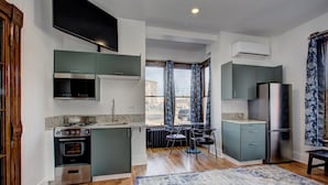 Una cucina moderna con forno integrato, microonde e frigorifero in acciaio inossidabile.