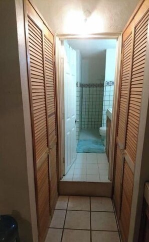 Leading to a bathroom with a toilet and shower area.