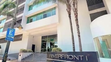 Un edificio moderno con un letrero que dice 'Riverfront Suites & Apartments'.