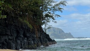 A beach with rocky cliffs and waves crashing onto the shore. - AC IN ALL 4 BEDROOMS! Recently renovated 4BD/3B Queen's Bath home w/Jacuzzi! (Princeville)