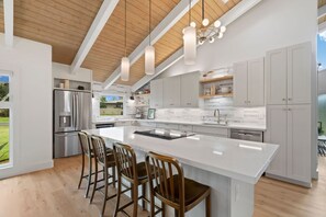 A modern kitchen with a large island, stainless steel appliances, and white cabinetry. - AC IN ALL 4 BEDROOMS! Recently renovated 4BD/3B Queen's Bath home w/Jacuzzi! (Princeville)