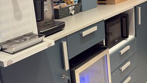 A kitchenette with a coffee machine, microwave, and storage drawers. - Divina Holiday  (Maiori)