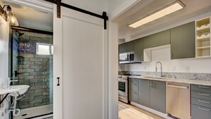 A modern kitchen with grey cabinets, a stainless steel sink, and a built-in oven.