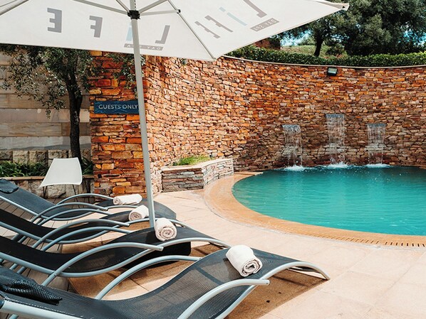 A poolside area with lounge chairs and a 'GUESTS ONLY' sign. - Southern Sun Silverstar (Krugersdorp)