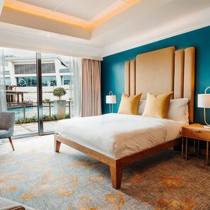 Une chambre d’hôtel moderne avec un grand lit, une table de chevet, une chaise et une vue sur l’extérieur.