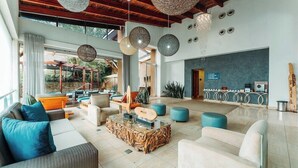 A spacious lobby with a modern design, featuring a mix of seating areas, a reception desk, and a view of the outdoors. - Southern Sun Silverstar (Krugersdorp)