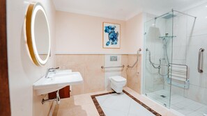A modern bathroom with a glass shower, a white sink, a toilet, and a framed artwork on the wall. - Southern Sun Silverstar (Krugersdorp)