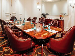 A conference room with a long table, leather chairs, and water bottles. - Southern Sun Silverstar (Krugersdorp)