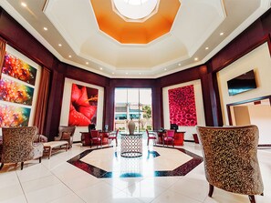 A lobby with a central seating area, a large window, and artwork on the walls. - Southern Sun Silverstar (Krugersdorp)