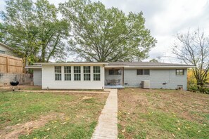 A single-story house with a front porch, a covered patio, and a visible air conditioning unit.
