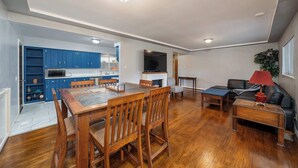Amplia sala de estar con una mesa de comedor de madera, un sofá y un televisor.