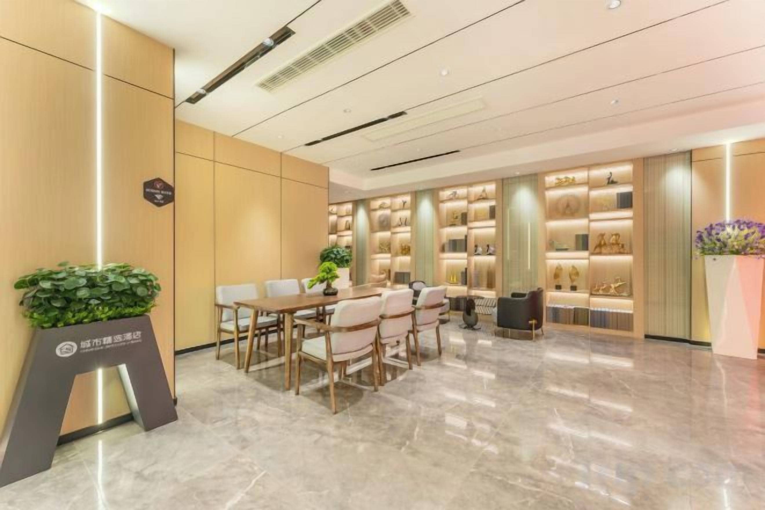 Un vestíbulo de hotel con una recepción, zona de estar y una exhibición de objetos.