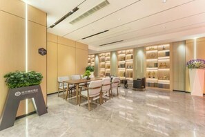 A hotel lobby with a reception desk, seating area, and a display of items. - Elegant Stay Hotel (Shantou Jinhul Road Store) (Shantou)