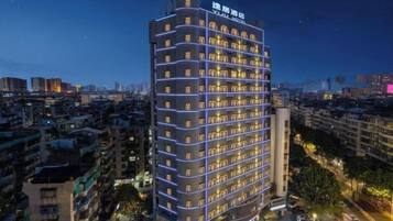 A high-rise hotel with multiple floors, a prominent sign at the top, and a view of the surrounding cityscape.