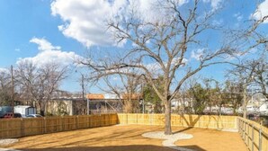 An outdoor area with a fenced enclosure, a tree, and a sign that reads "Central."