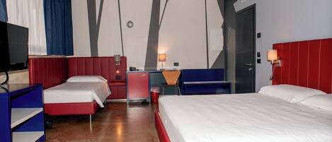 A hotel room with two beds, a desk, a chair, a TV, and a wardrobe.