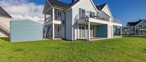 A two-story house with a balcony, a covered porch, and a garage.