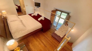 A bedroom with a bed, bedside lamps, a TV, and a window with a view. - 1 bedroom beautiful apartment in Firenze (Firenze)