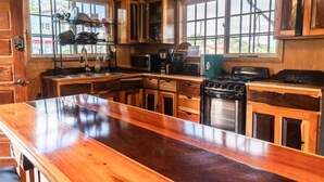 Une cuisine avec des meubles en bois, une cuisinière en acier inoxydable, un four à micro-ondes et un évier.