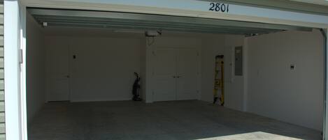 En garage med et rent, tomt interiør, nummer 2801 på garagedøren, og en stige lænet op ad væggen.