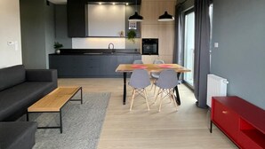 A modern living space with a kitchen, dining area, and seating. - Poznan Surburb Apartament (Skórzewo)