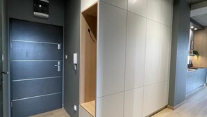 A modern interior with a dark door, a light-colored wardrobe, and a wooden floor. - Poznan Surburb Apartament (Skórzewo)